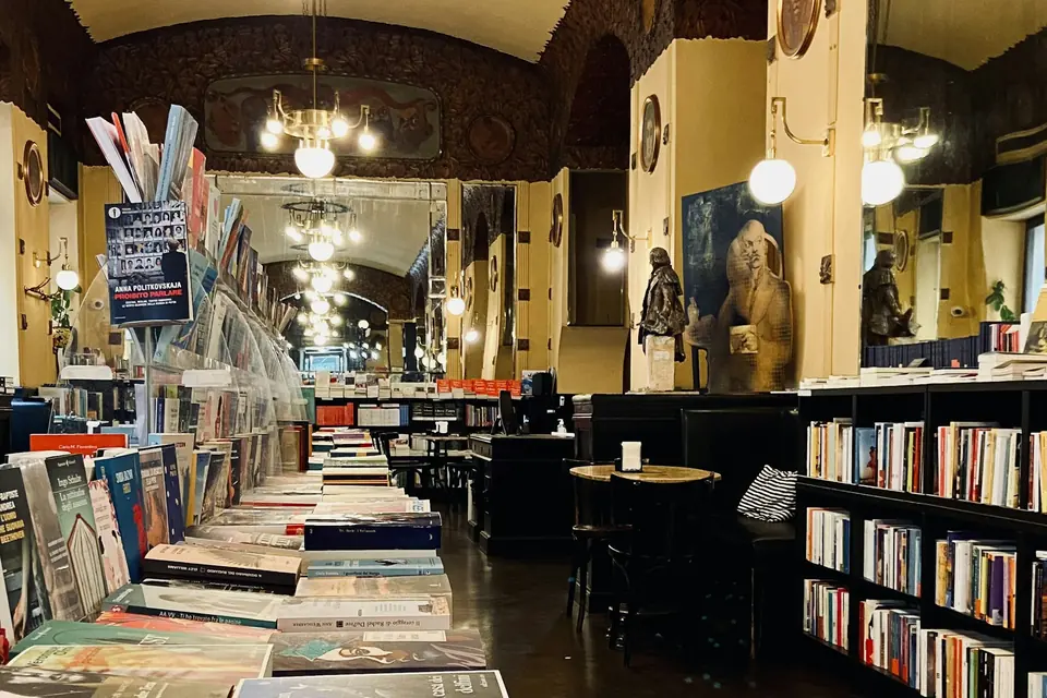 L’interno di un caffè storico con libreria, lampadari e scaffali di libri