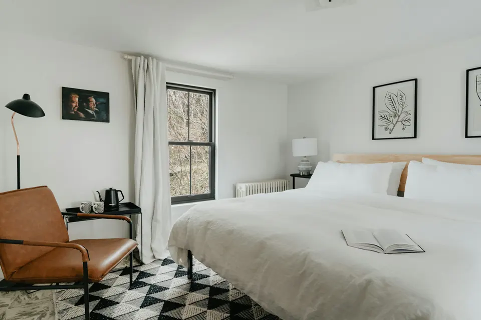 Camera Bora: poltrona in pelle, lampada e letto matrimoniale