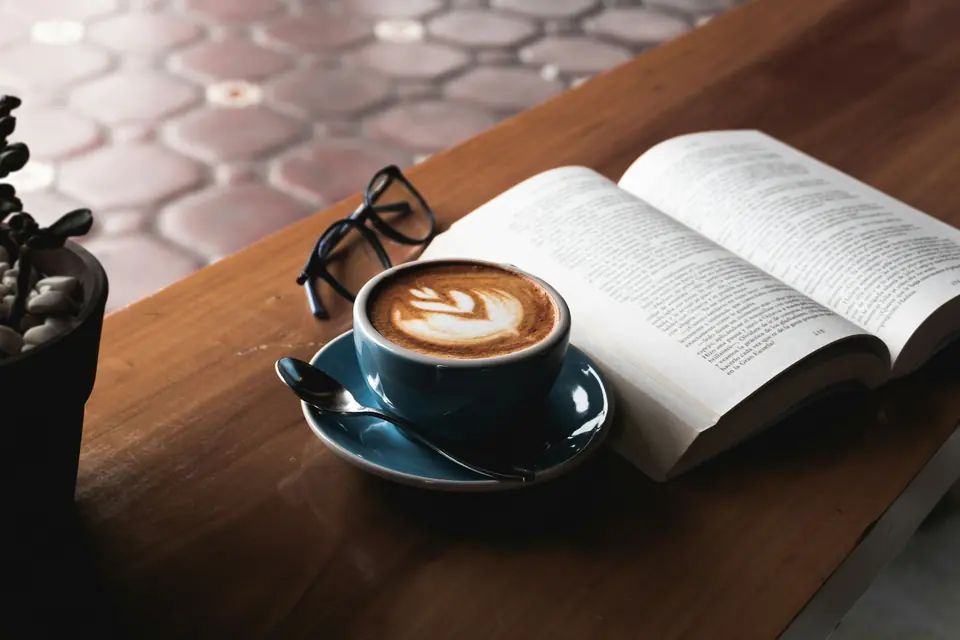 Tazza di caffè su un tavolo in legno con una mappa di Trieste